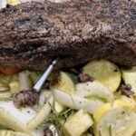 Sonda in acciaio del termometro wireless MEATER 2 Plus inserita in un arrosto di carne in cottura con verdure.