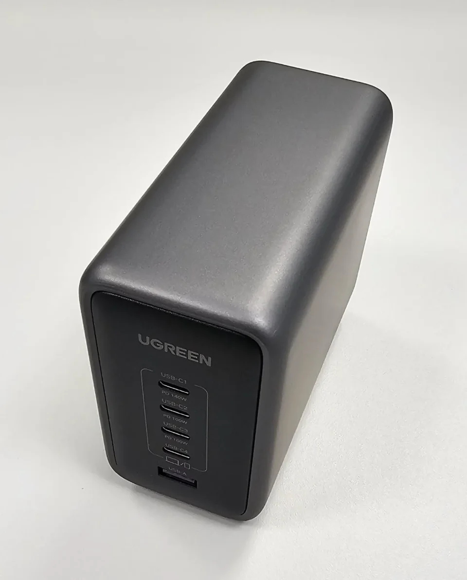 Vista angolata del caricatore desktop UGREEN dal design compatto e minimale color grigio scuro, raccomandato come accessorio tech nel 2026.