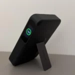 Vista laterale di un power bank Anker nero con kickstand aperto e display digitale che segna il 100% di batteria, tra i top accessori tech 2026.