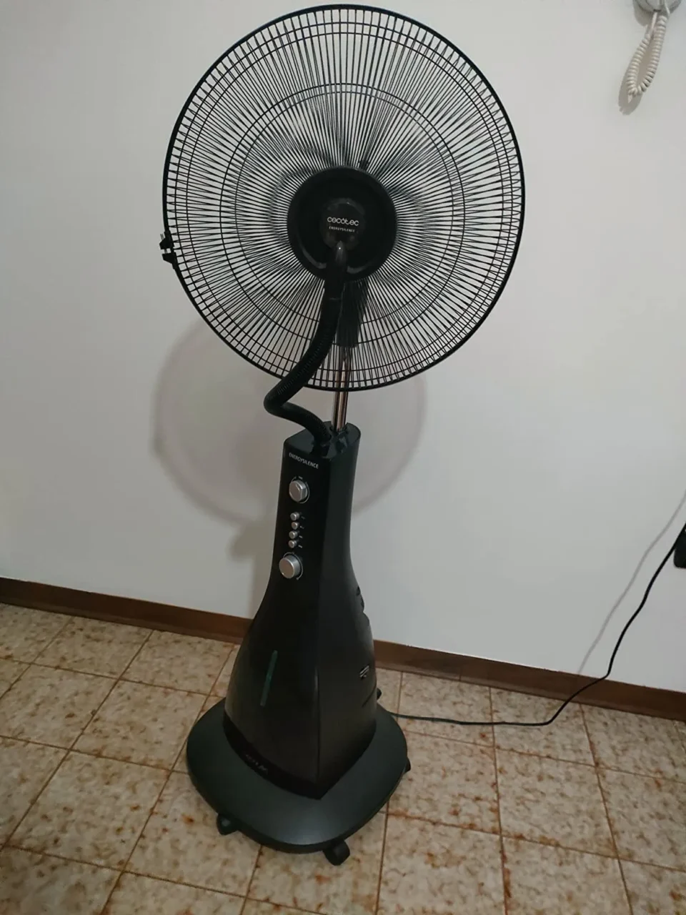 Vista intera del ventilatore a piantana Cecotec nero con il capiente serbatoio per l'acqua alla base e tubo di raccordo frontale.