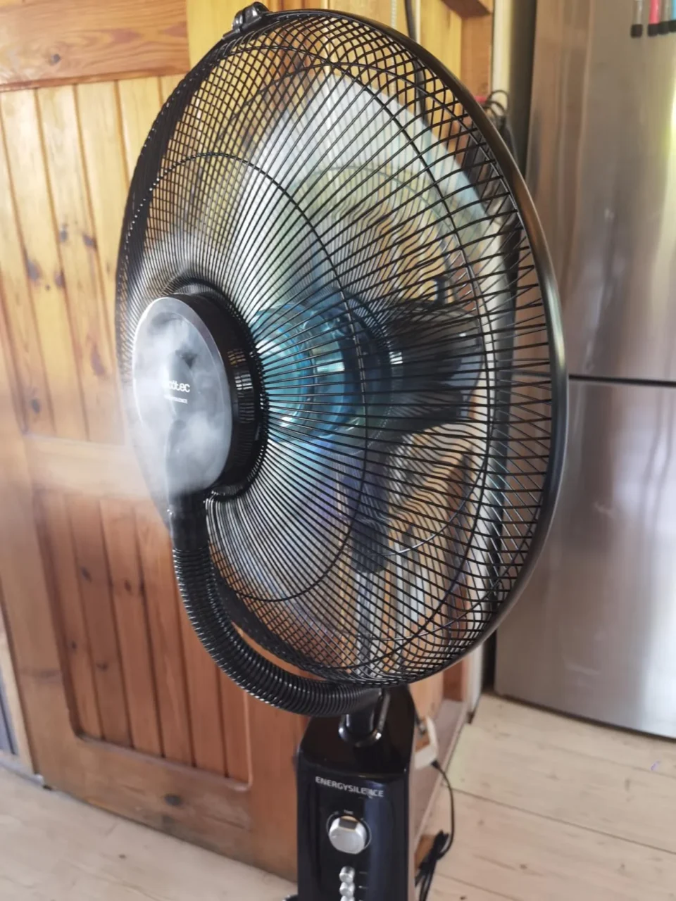 Ventilatore a piantana Cecotec in funzione che emette una visibile nebbia d'acqua rinfrescante dalle pale, ideale per abbassare la temperatura percepita e prevenire il colpo di calore.
