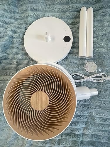 Componenti smontati del ventilatore smart SwitchBot appoggiati su un tessuto azzurro, tra cui il motore brushless, l'asta modulare a incastro e il telecomando.