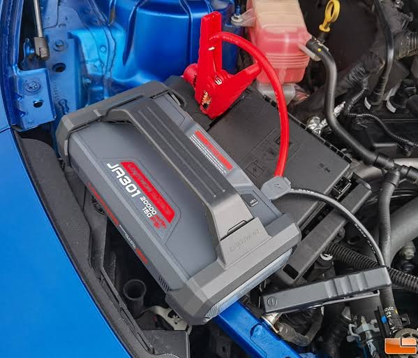 Avviatore emergenza auto multifunzione Lokithor JA301 collegato con le pinze di sicurezza alla batteria di un'auto per il jump start.