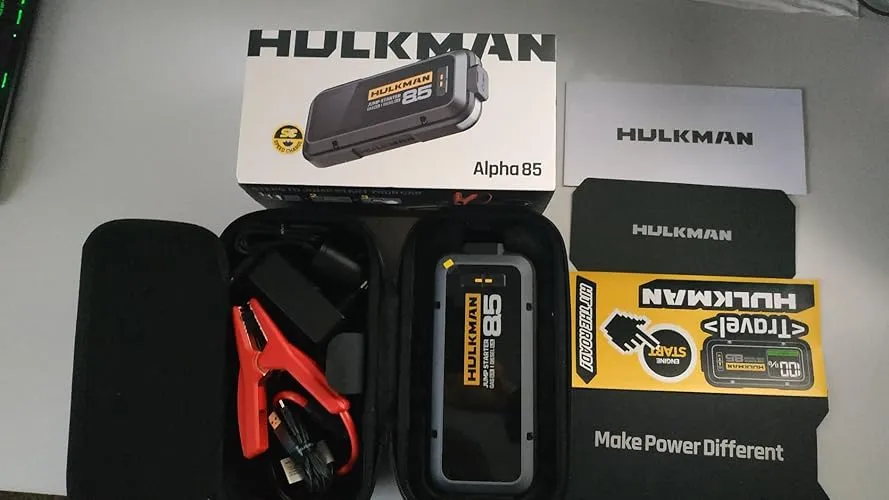 Kit completo dell'avviatore emergenza auto HULKMAN Alpha 85 con scatola originale, custodia rigida aperta, pinze intelligenti antiscintilla e manualistica.